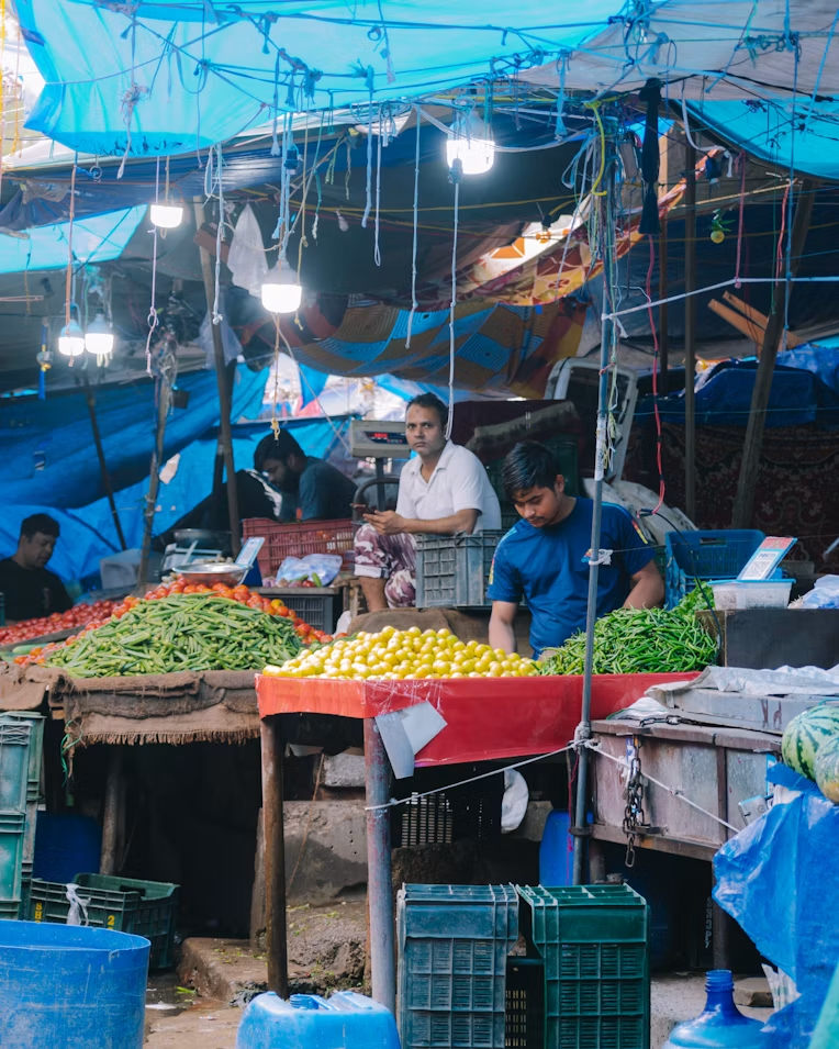Fresh produce displayed by vendors at an agricultural market
